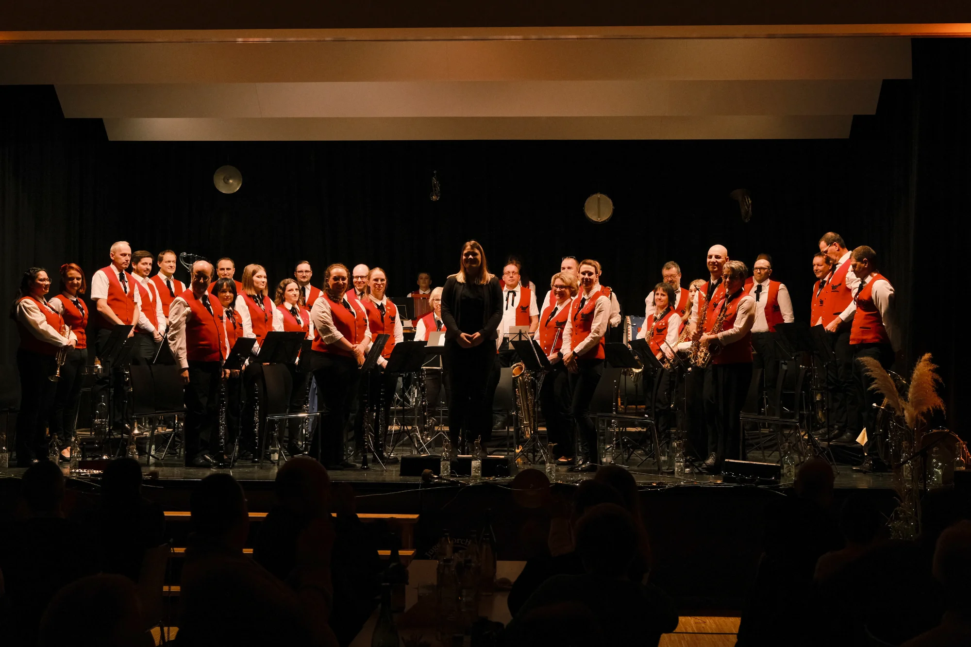 Das Hauptorchester des Musikvereins Kollmarsreute in roten Westen auf der Bühne eines Konzertsaals